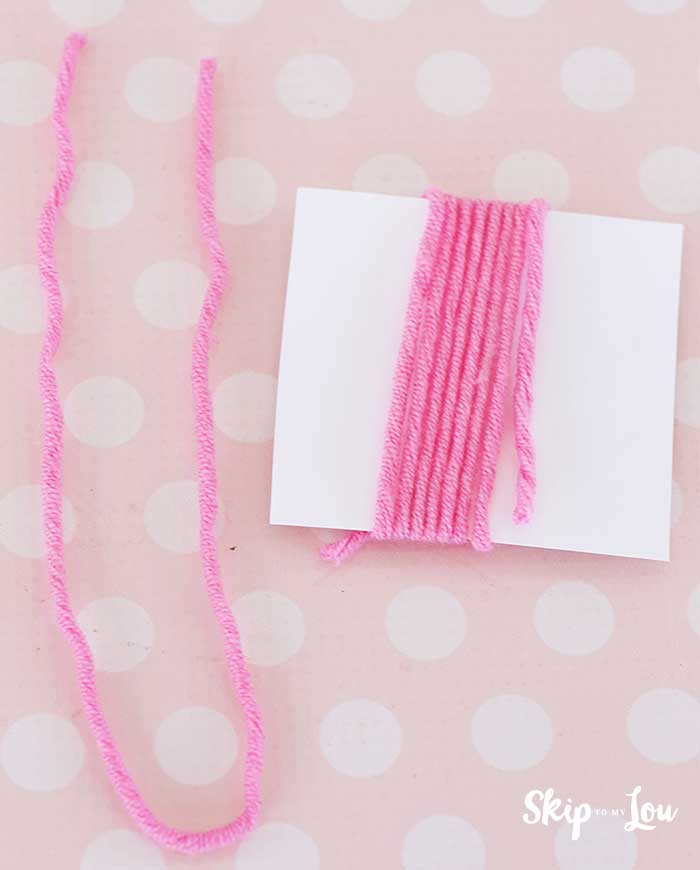 piece of yarn beside card wrapped with yarn