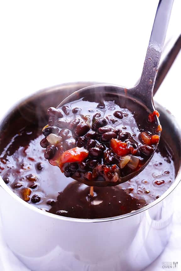 bean soup in metal pot ladle scooping up soup