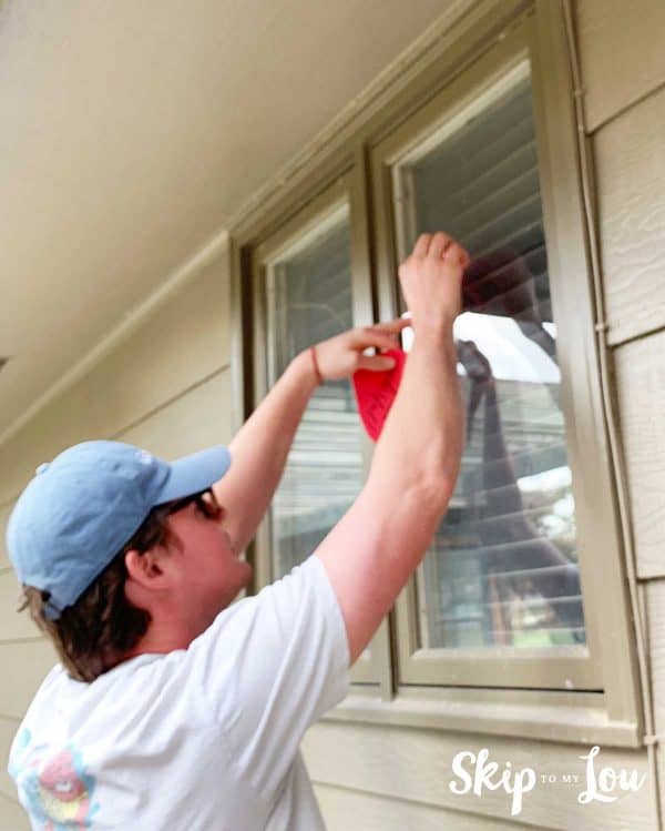 boy putting heart on outside window