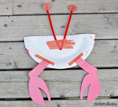 The base of the V taped to the back flat edge of the paper plate with crab legs taped to the rounded side