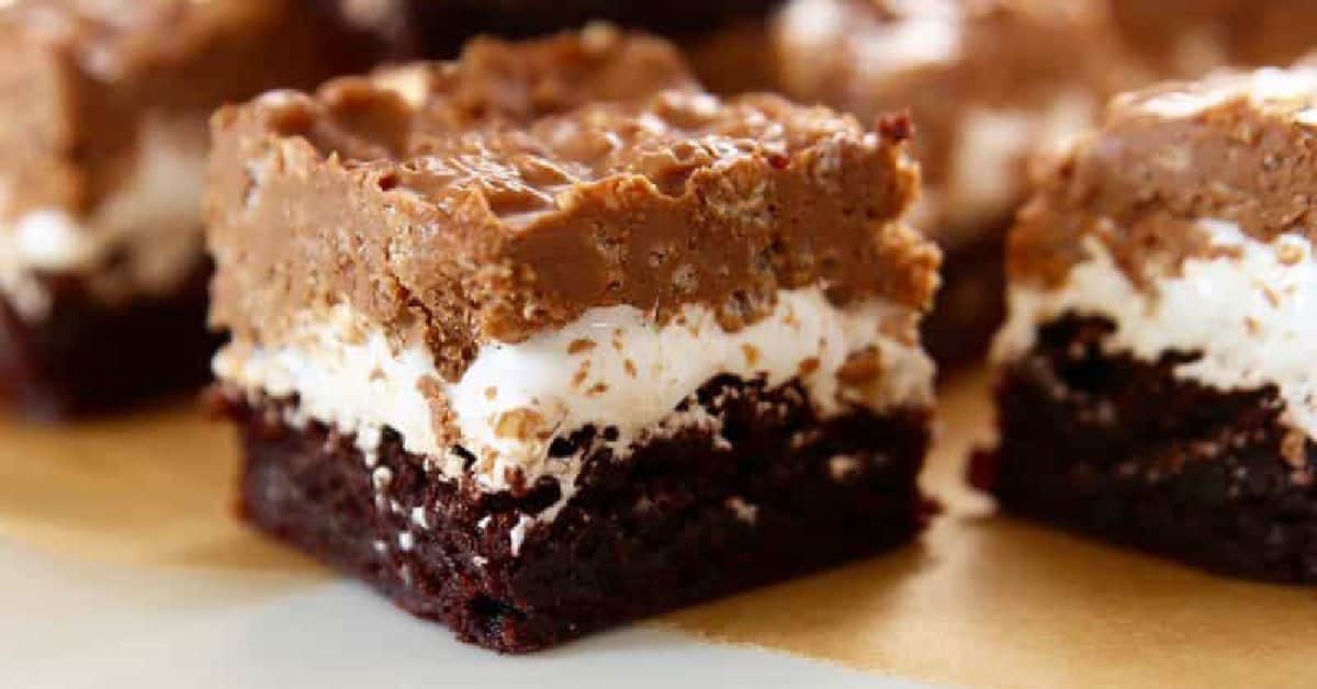 chocolate crunch brownies on plate layers of rice krispies, marshmallow and peanut butter brownies