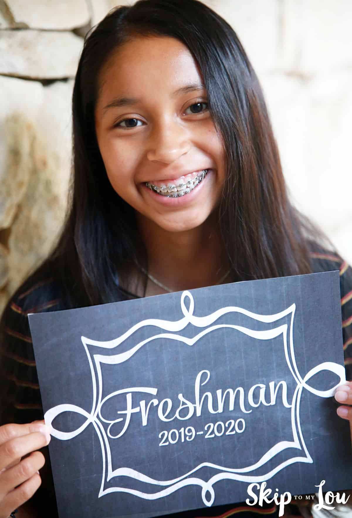 girl holding back to school chalkboard sign 2019