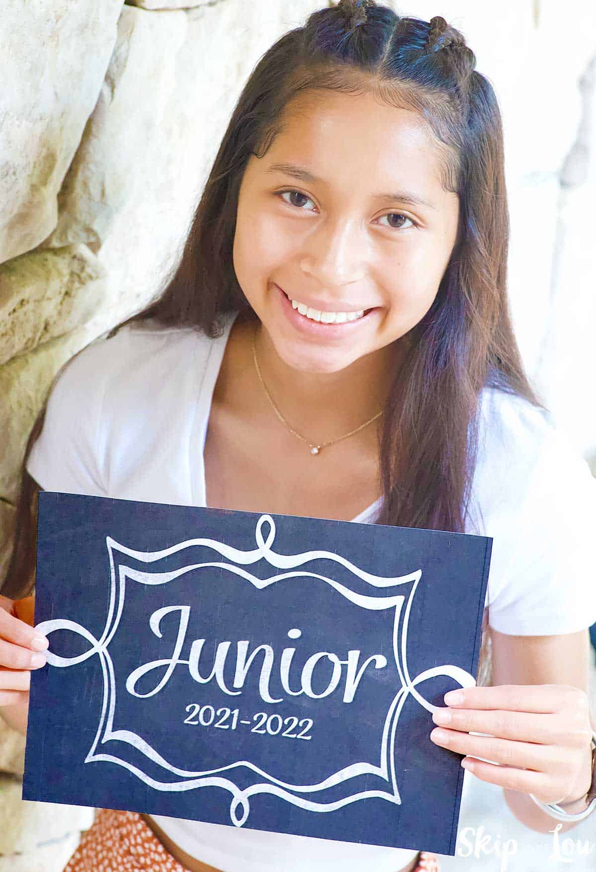 child holding sign for first day of school