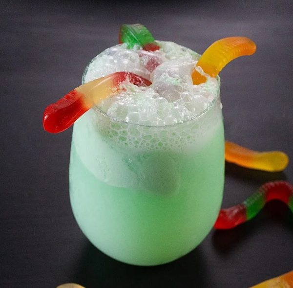 Image shows a punch cocktail decorated with gummy worms for halloween