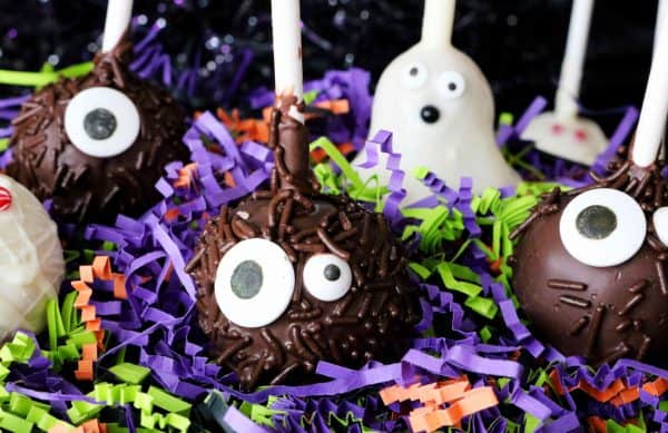 Image shows Halloween-themed cake pops over a decorated table