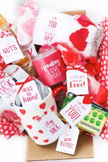 box filled with small red and white gifts box of love care package