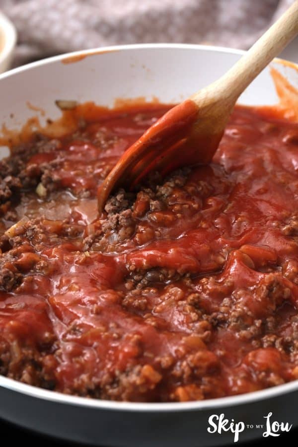 pasta sauce added to the browned ground beef in a skillet