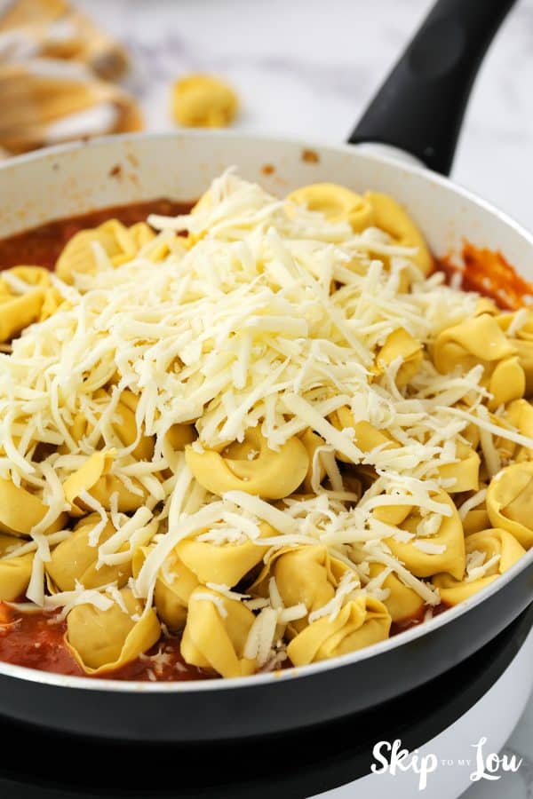 cooked tortellini and mozzarella cheese have been added to the sauce mixture in the skillet