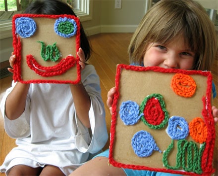 preschool children holding yarn mosaics