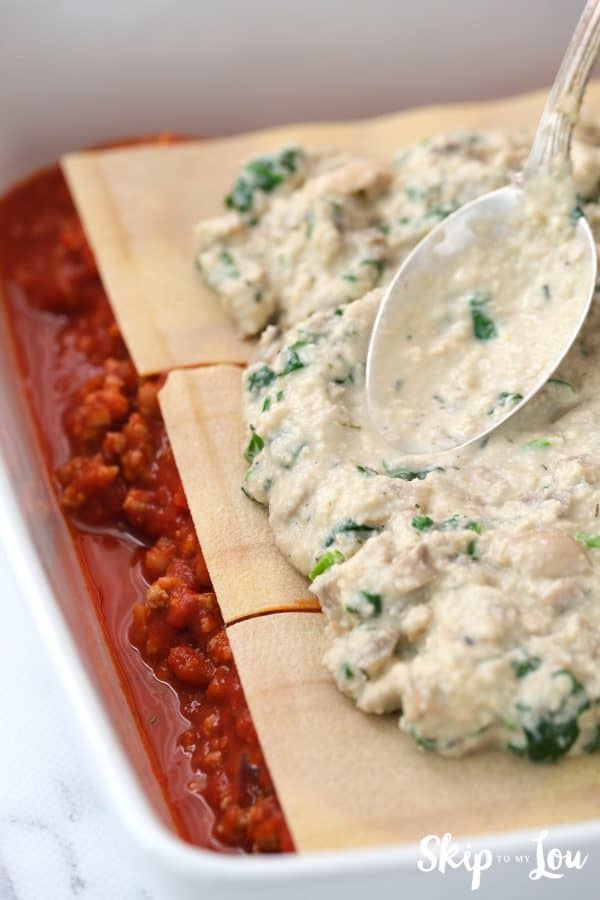 base layer of marinara, uncooked gluten free lasagna noodles, layer of mushroom cashew cream sauce in a white casserole dish