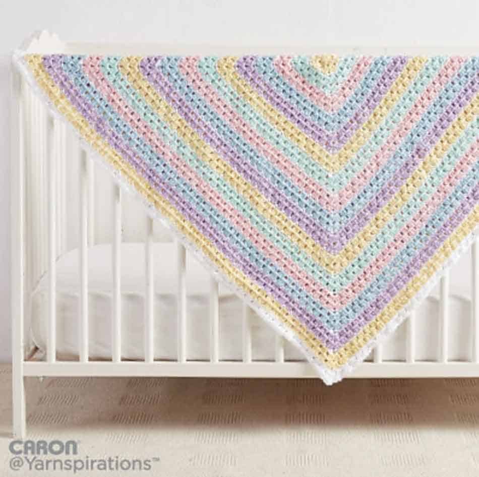 pastel rainbow blanket on white crib