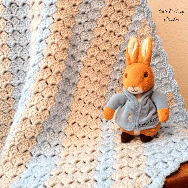 baby boy blue blanket with stuffed bunny sitting on corner