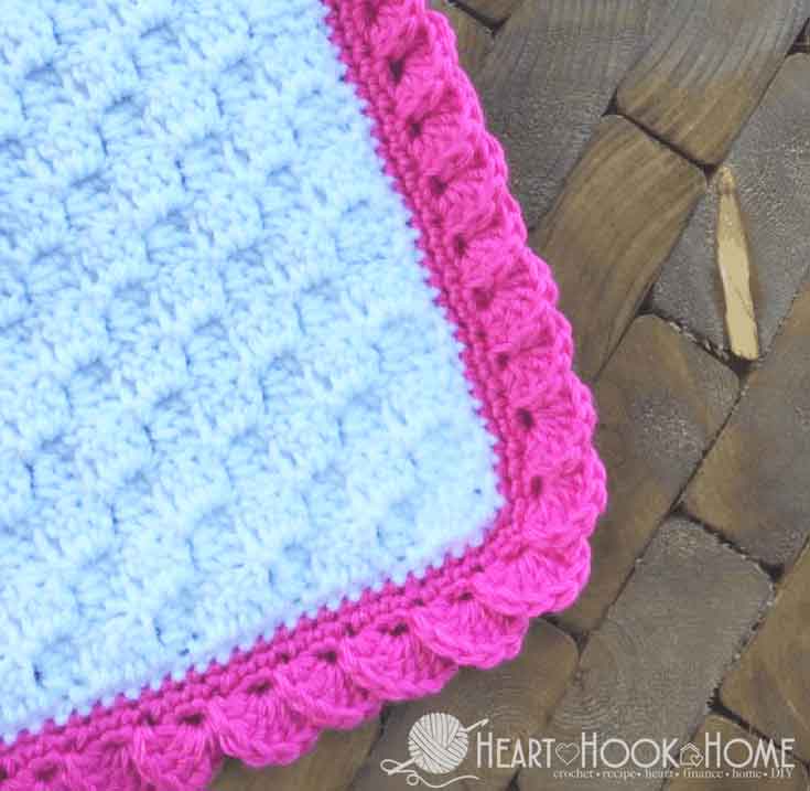 white blanket with pink reverse shell border