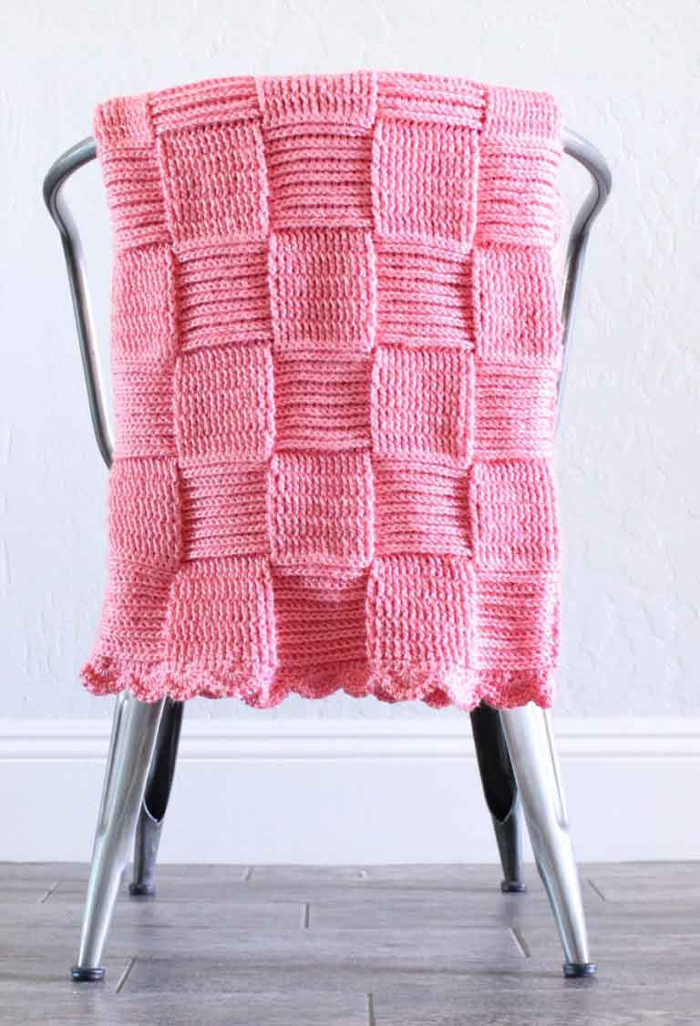 pink basket weave blanket on metal chair