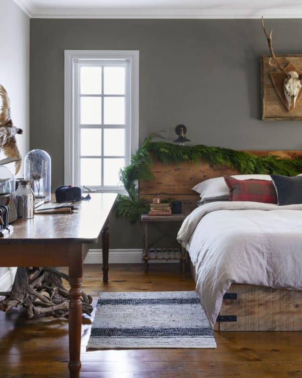 Image shows Holiday greenery on headboard in a cozy room.