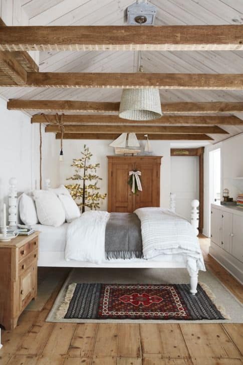 Image shows a mini christmas tree in a cozy bedroom