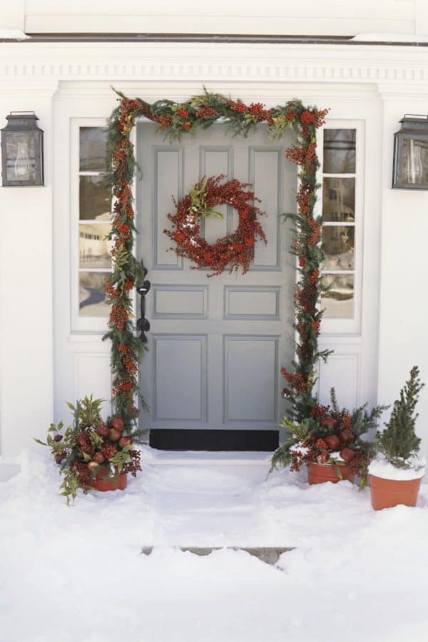 Image shows a Christmas berry garland on a grey door.