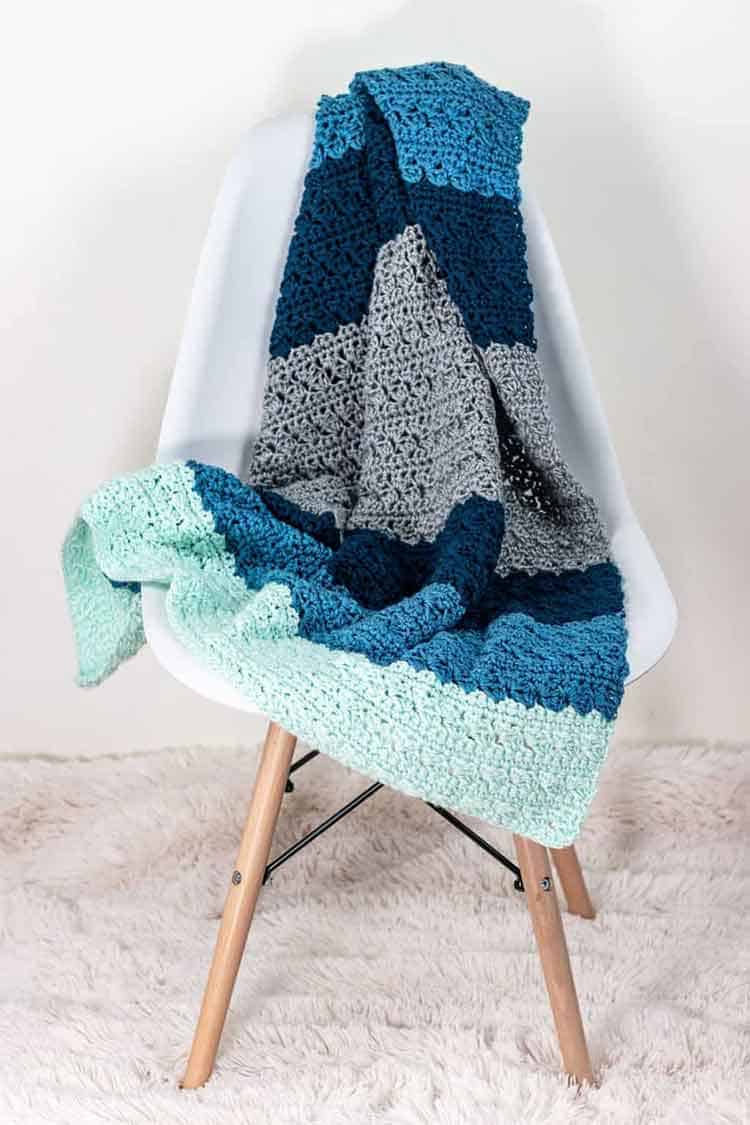 wide striped blanket laying on white chair
