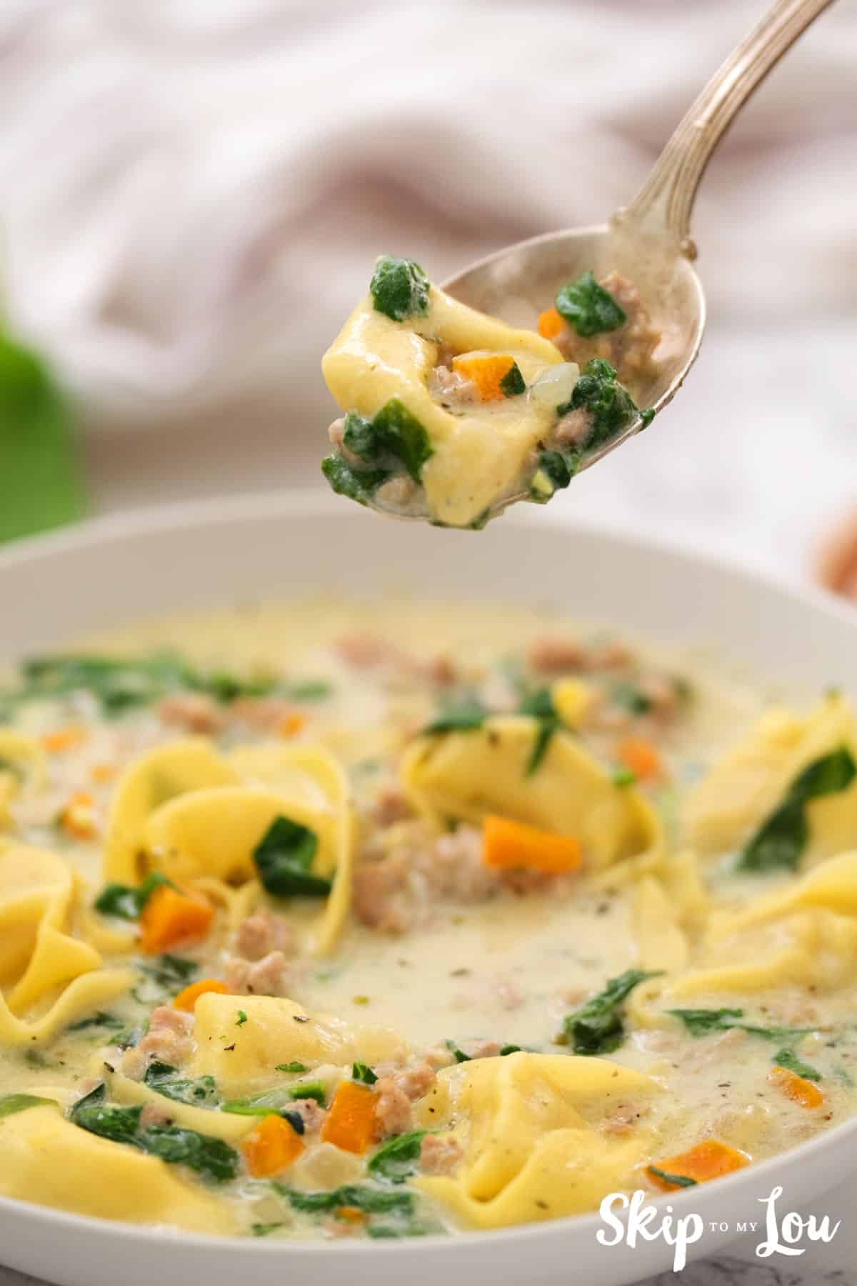 bowl of sausage tortellini soup with spoonful of soup