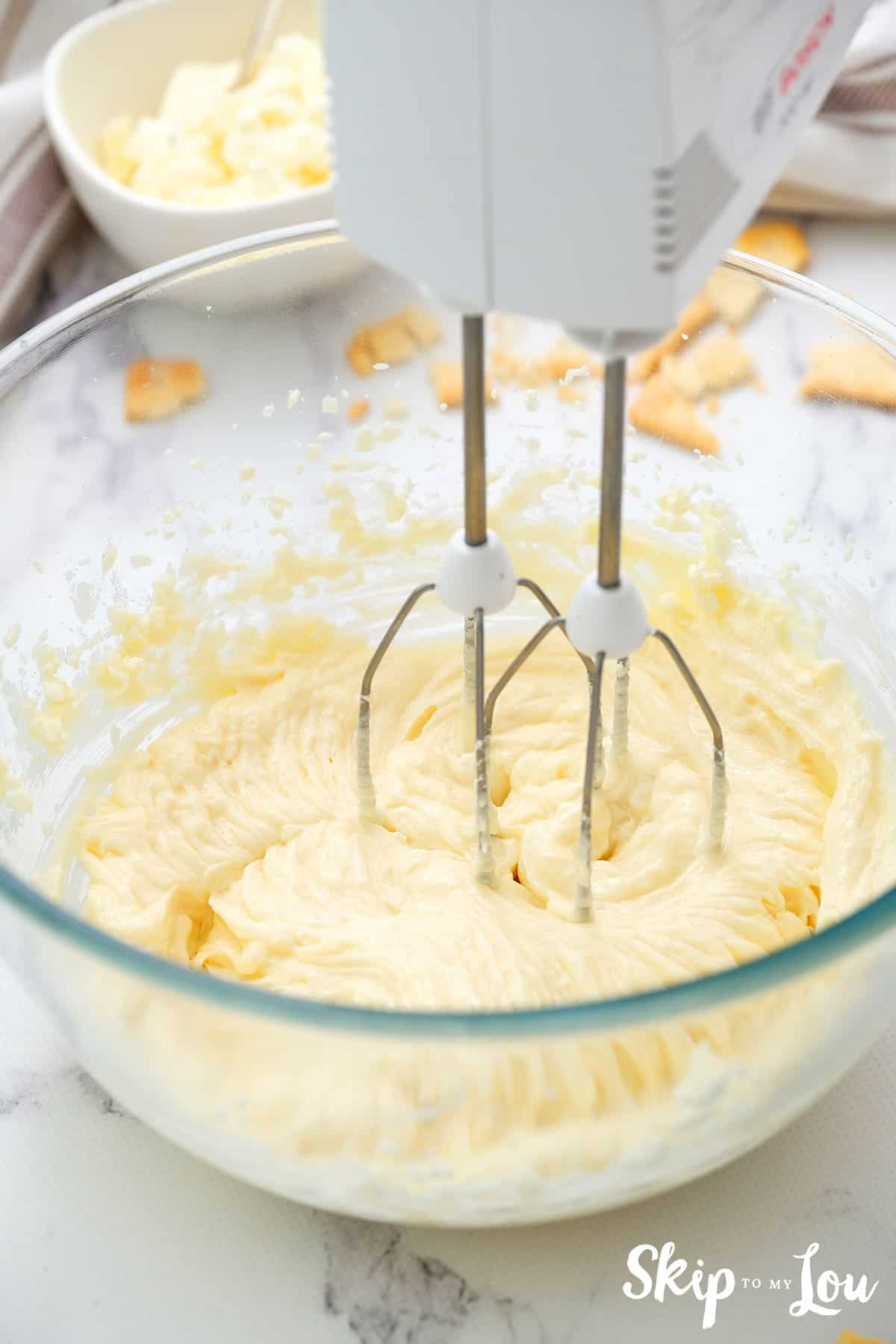 cream cheese and sugar in bowl with mixer