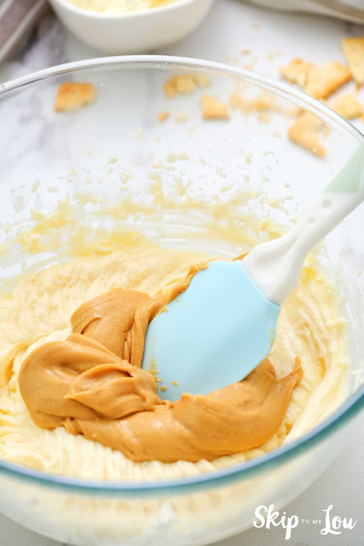 peanut butter and cream cheese in bowl with spatula stirring