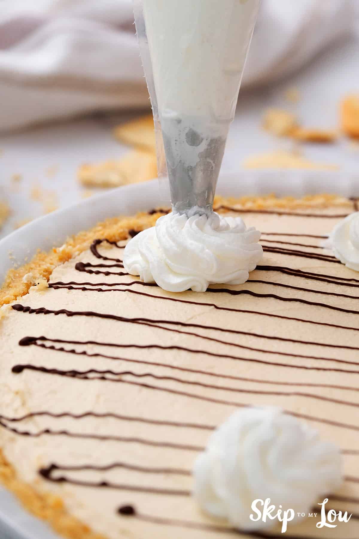 piping whipped cream on top of pie
