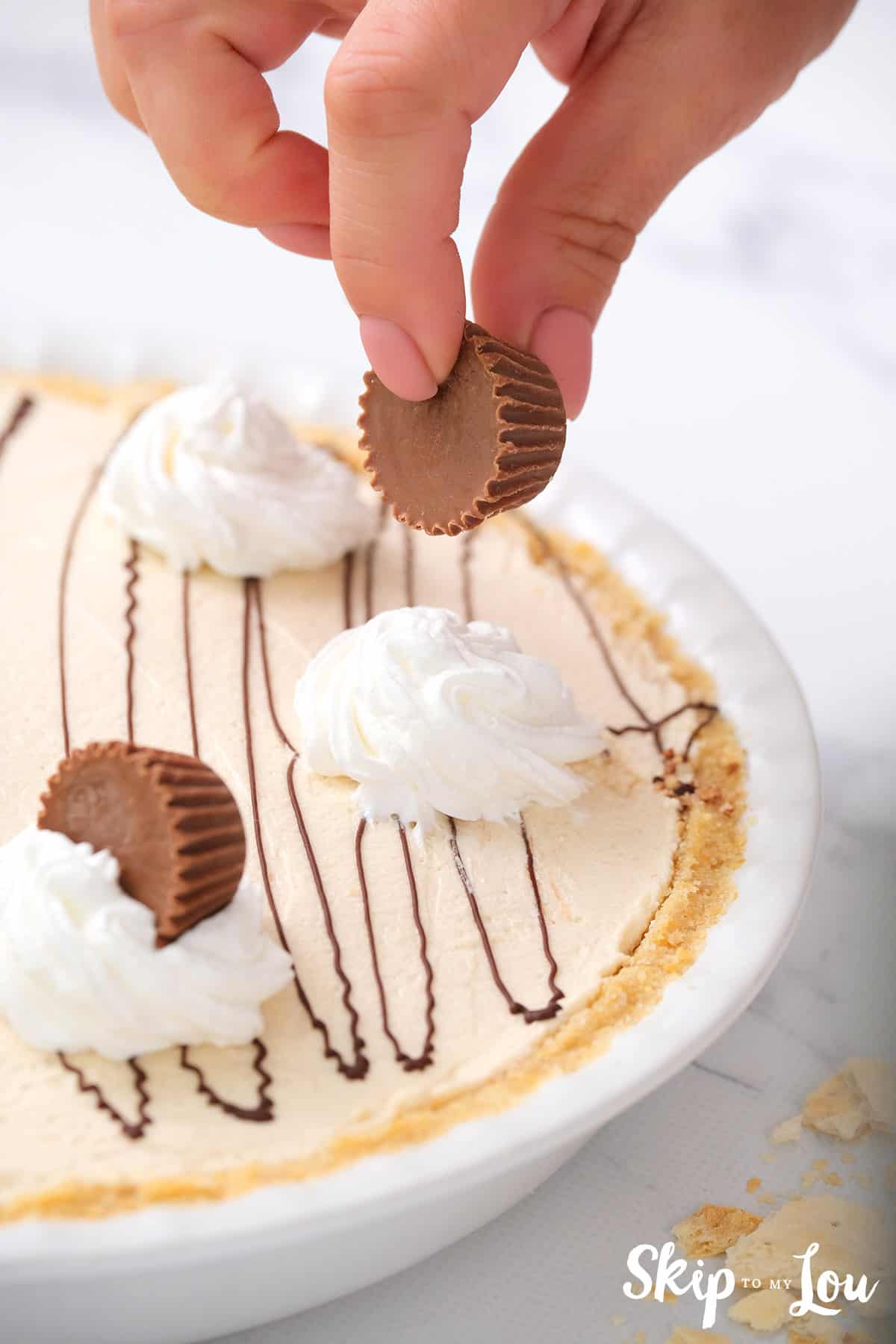 adding peanut butter cup garnish on top of no bake peanut butter pie