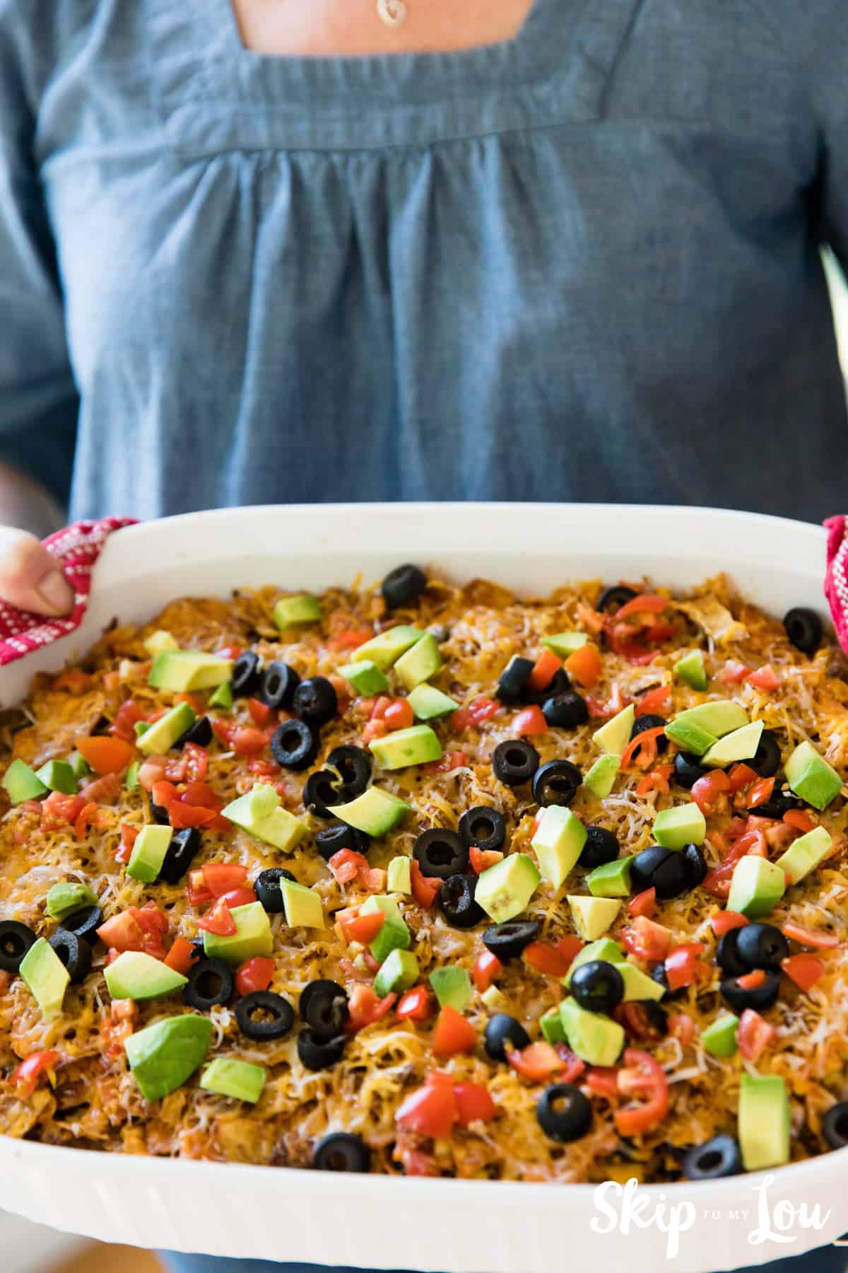 Doritos Casserole in white dish being held