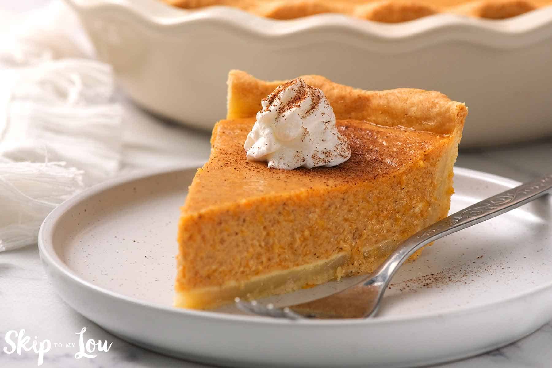 slice of pumpkin pie on white plate with fork