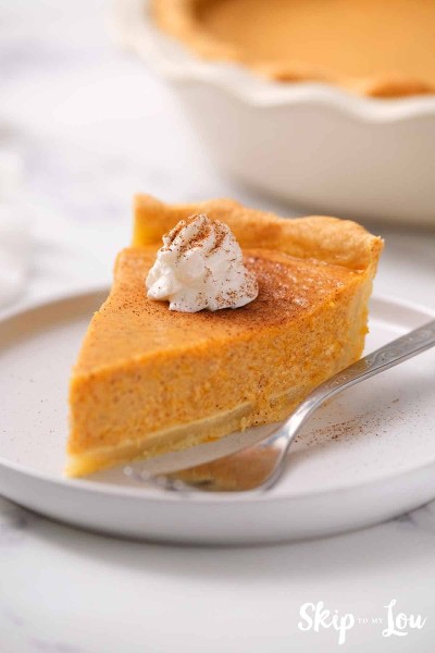 slice of pumpkin garnished with whipped cream and dusting of cinnamon