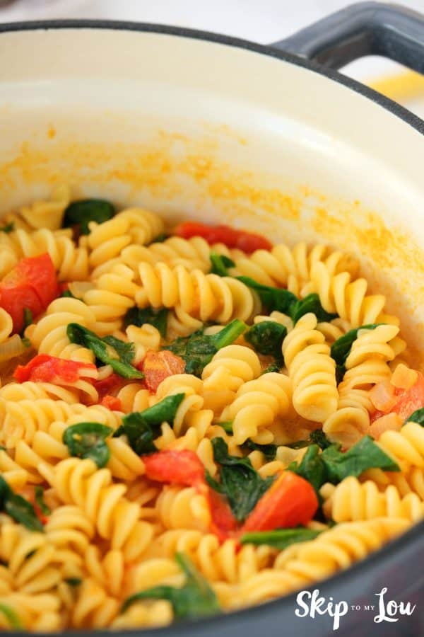 cooking creamy pasta until spinach is wilted