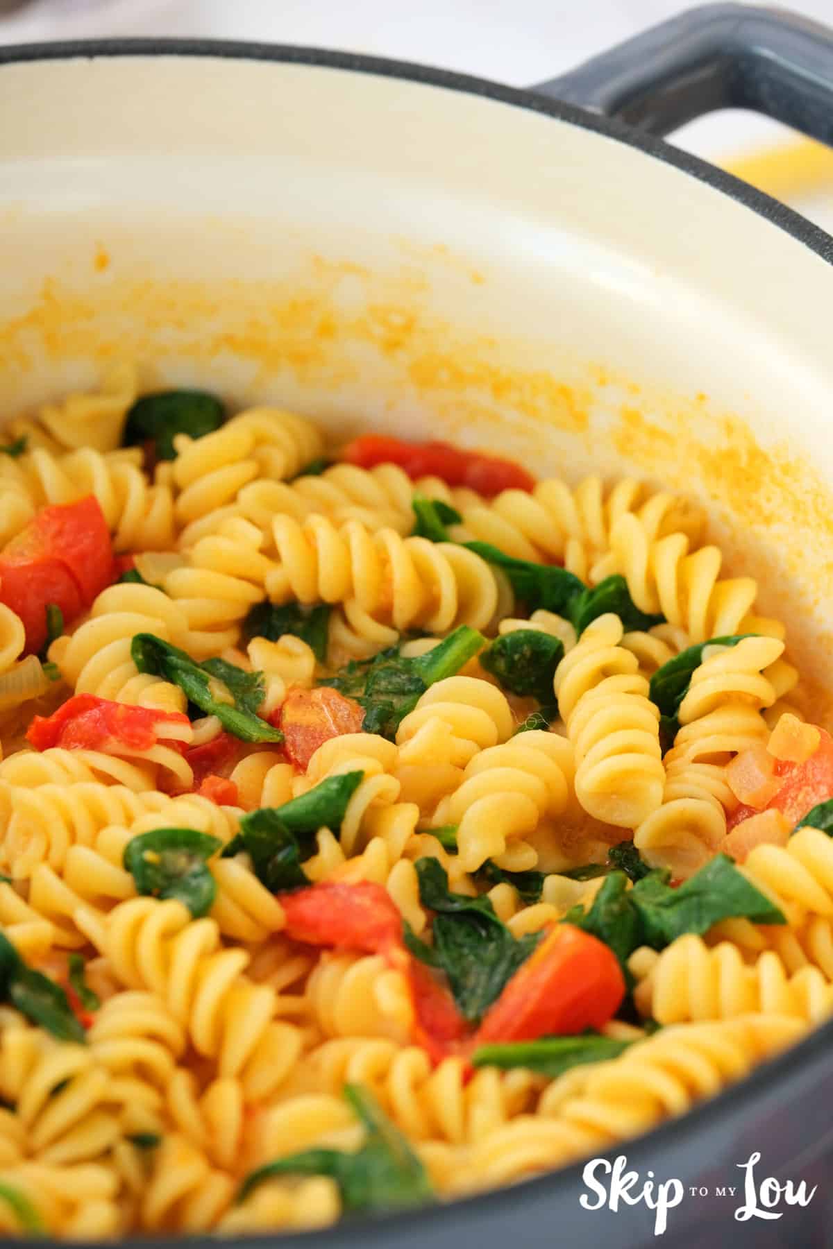 cooking creamy pasta until spinach is wilted