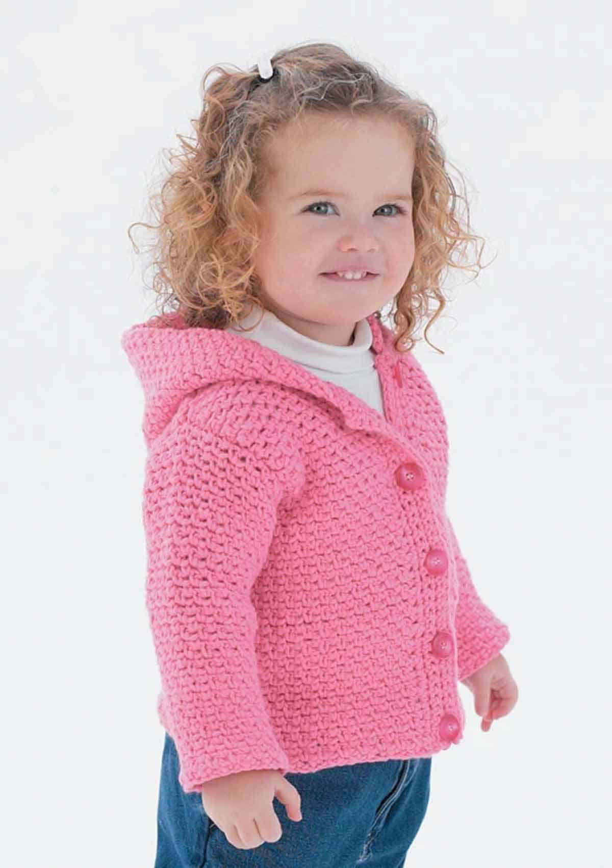Image shows a girl wearing a pink button up hoodie crochet sweater. Skip To My Lou