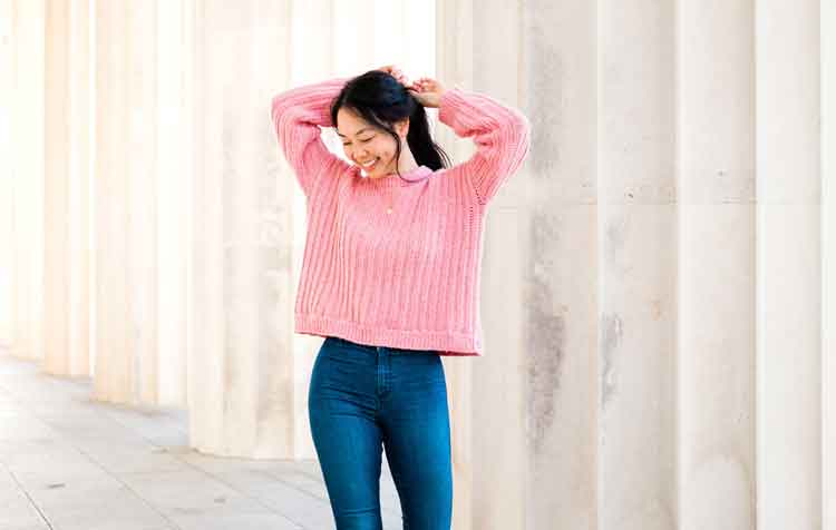 Image shows a woman wearing a pink ribbed oversized crochet sweater. -Skip To My Lou