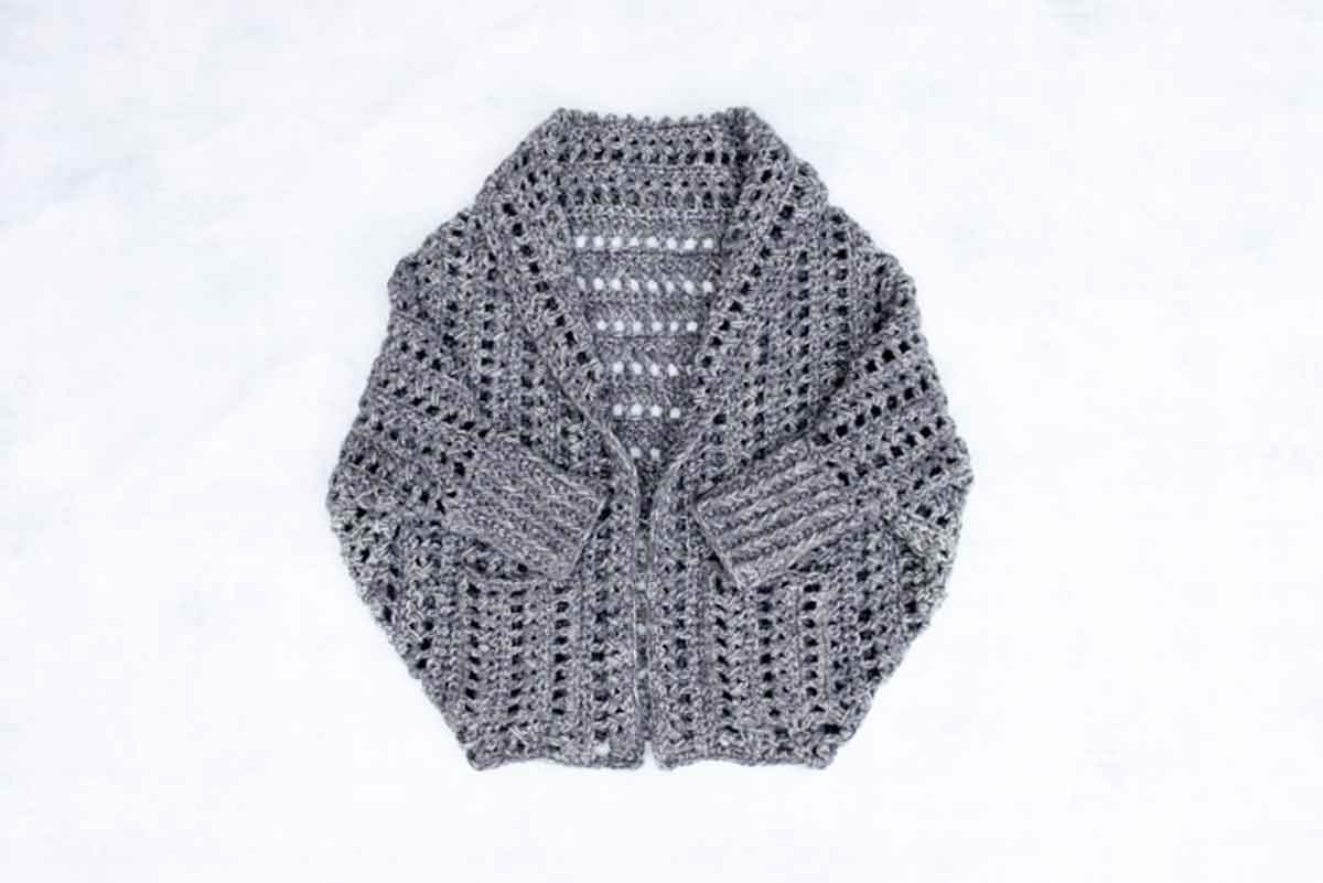 Image shows a gray chunky crochet sweater pattern. -Skip To My Lou

