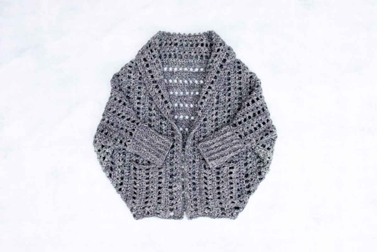 Image shows a gray chunky crochet sweater pattern. -Skip To My Lou