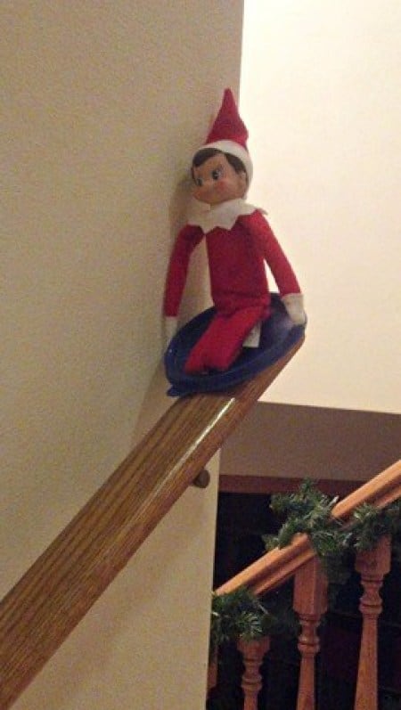elf sledding on banister