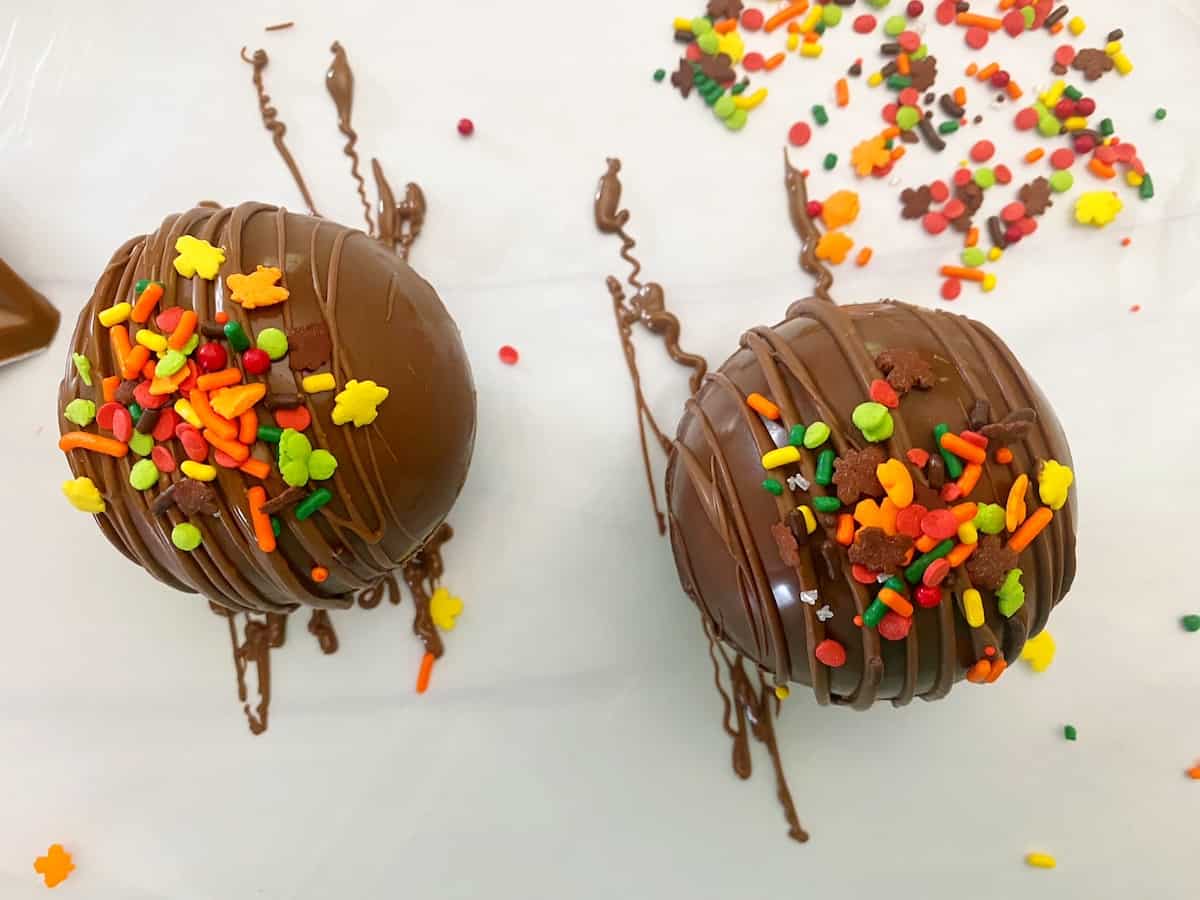 cocoa bombs sprinkled with fall sprinkles
