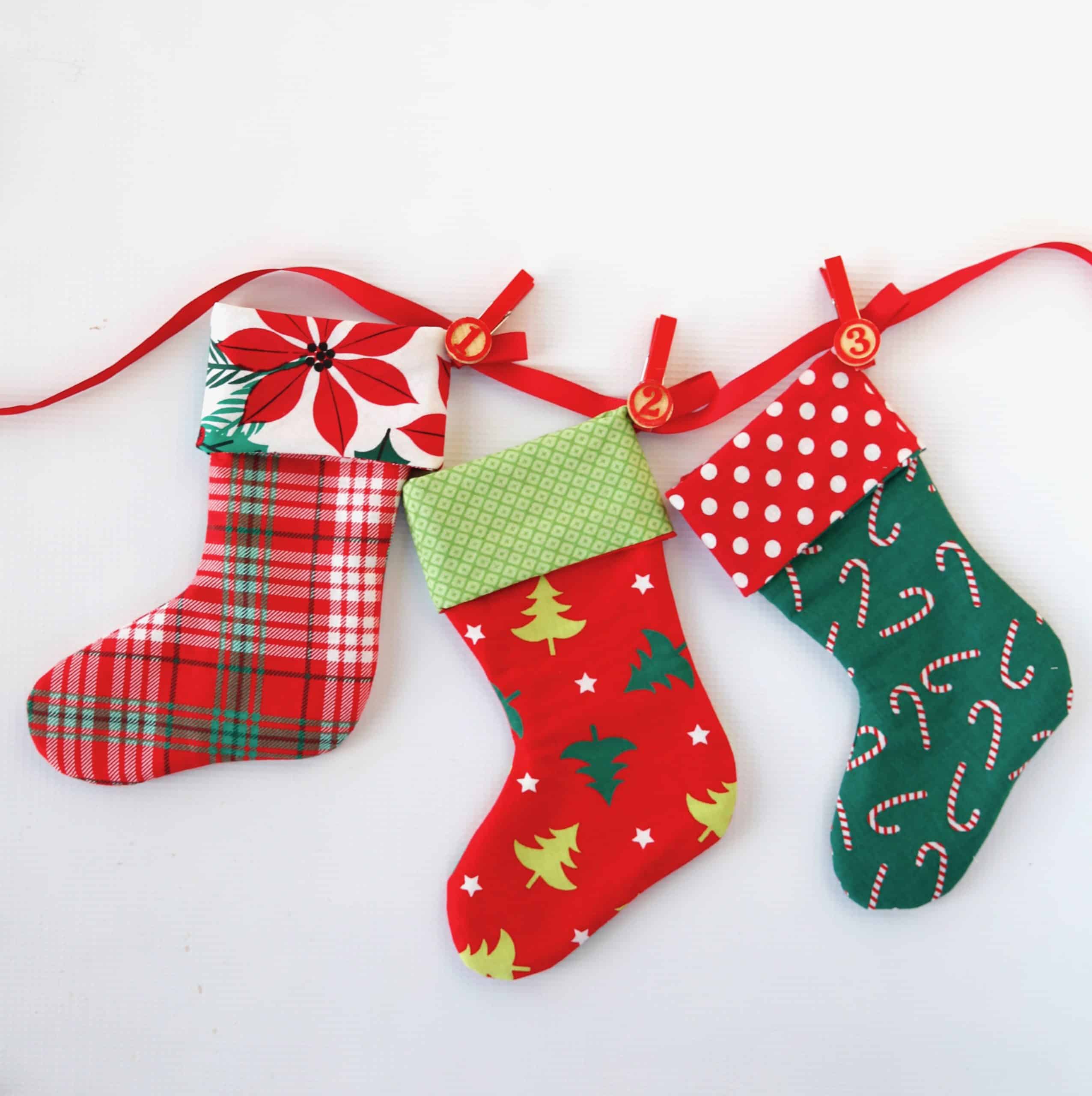 Christmas stocking advent calendar sewn attached to ribbon with red clothes pins with wooden numbers glued on.