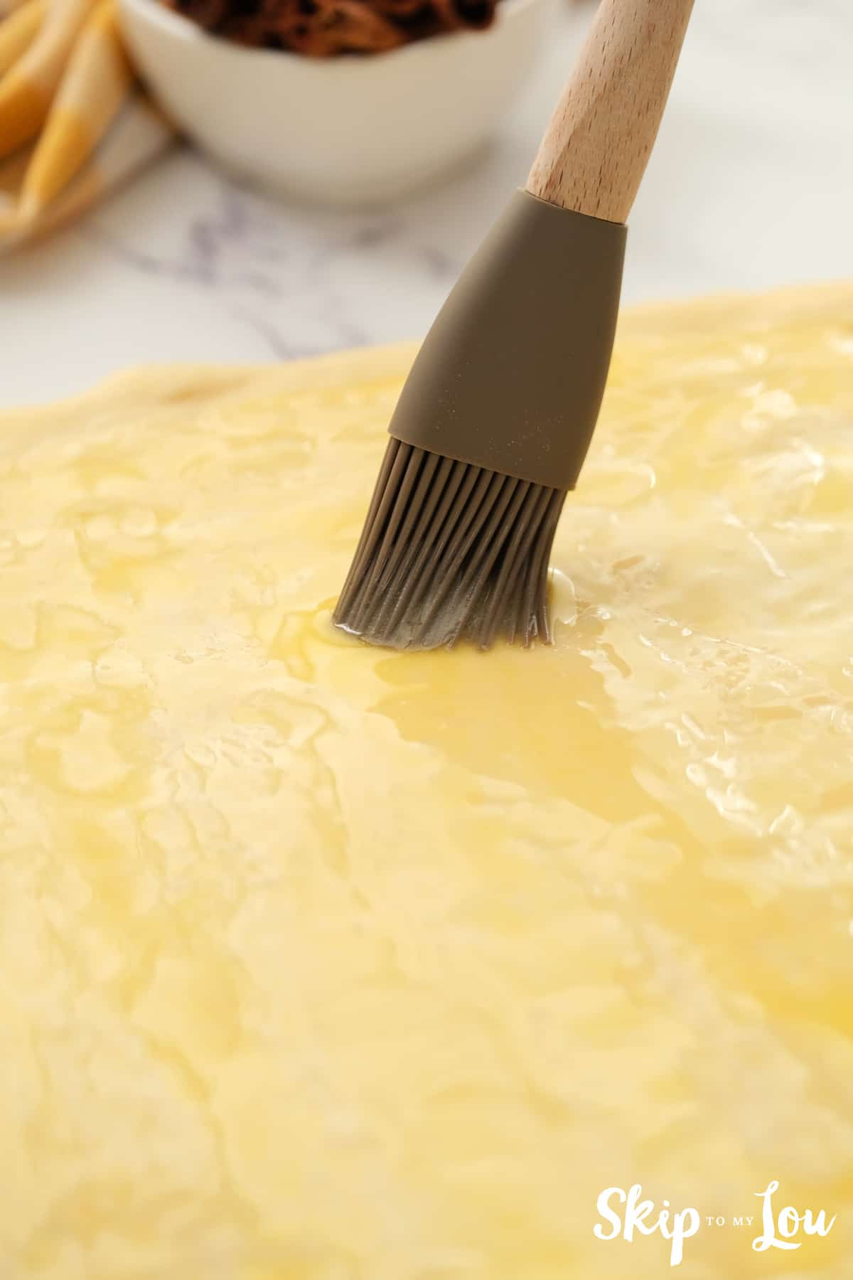 spread melted butter over top of the dough for the cinnamon roll recipe