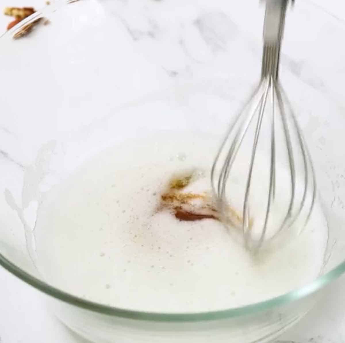 beaten egg whites with vanilla in bowl