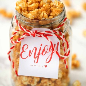 homemade caramel corn in glass jar with enjoy gift tag