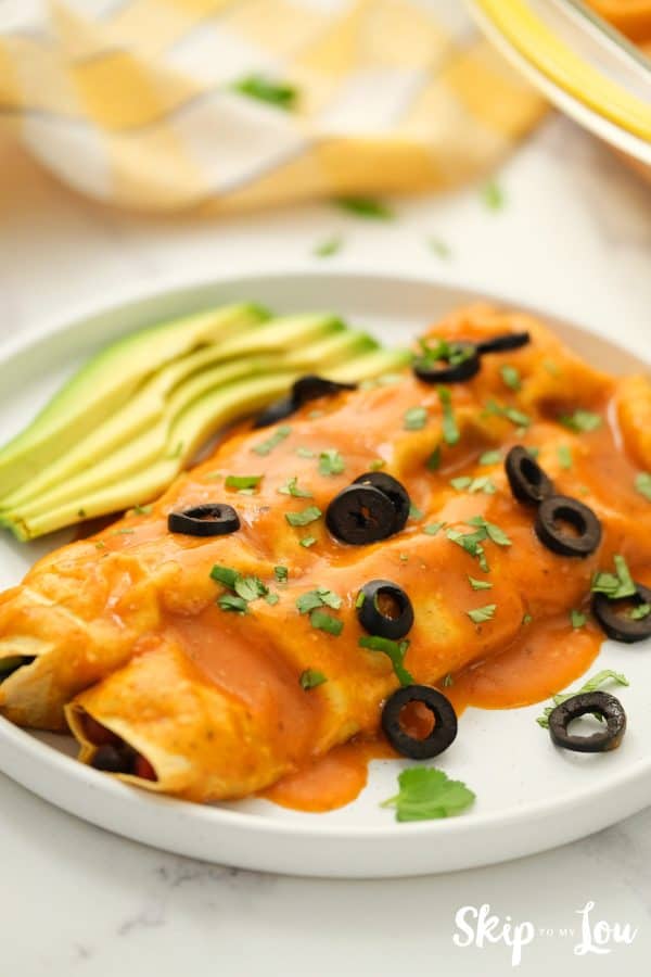 Vegan Enchiladas served with avocado slices and olives
