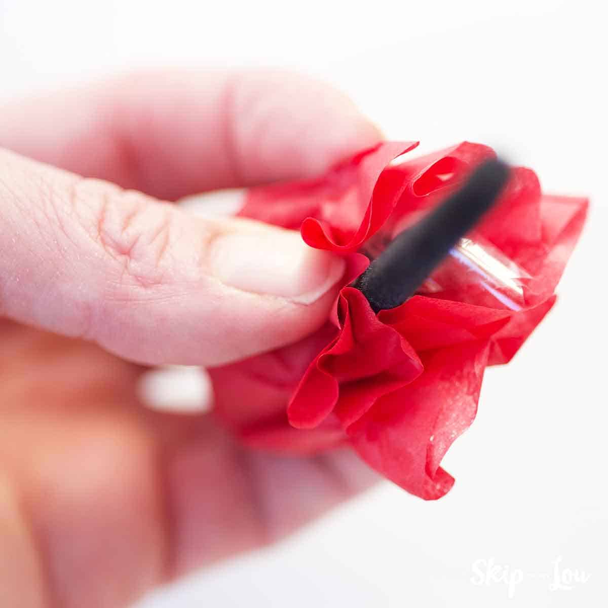 red tissue paper wrapped around Lindt chocolate with black pipe cleaner