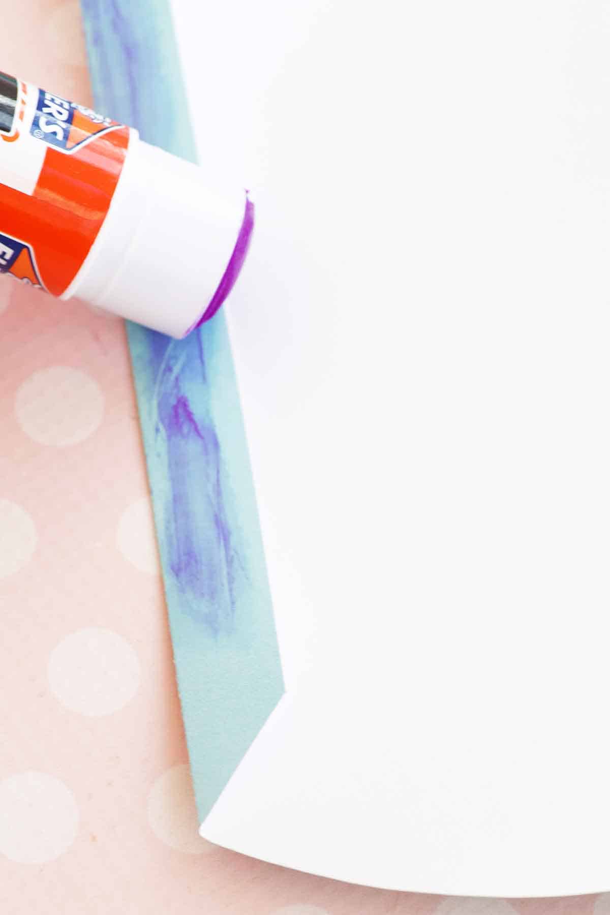 applying glue stick to flap of pillow box