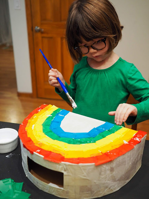 little girl making rainbow valentine box