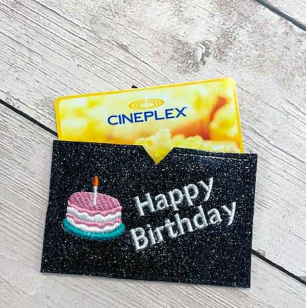 Image shows a gift card holder made with an in the hoop embroidery machine with the words " Happy birthday"