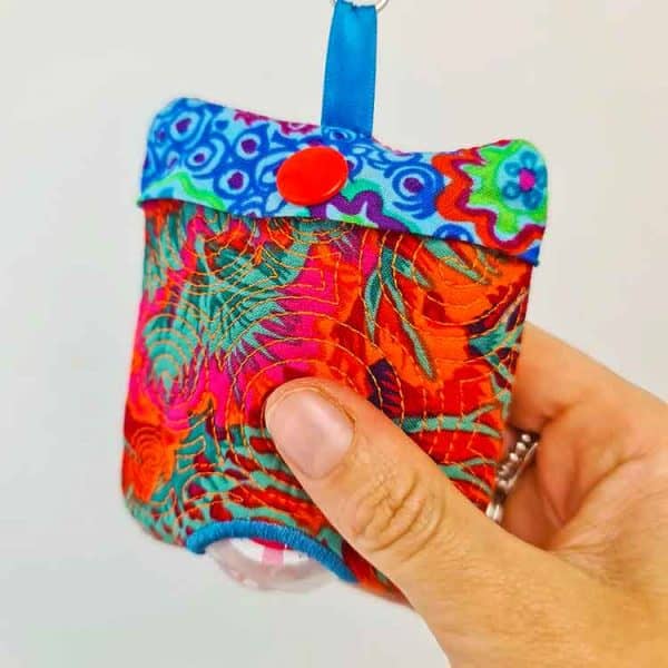 Image shows a hand sanitizer cover made with an embroidery machine.