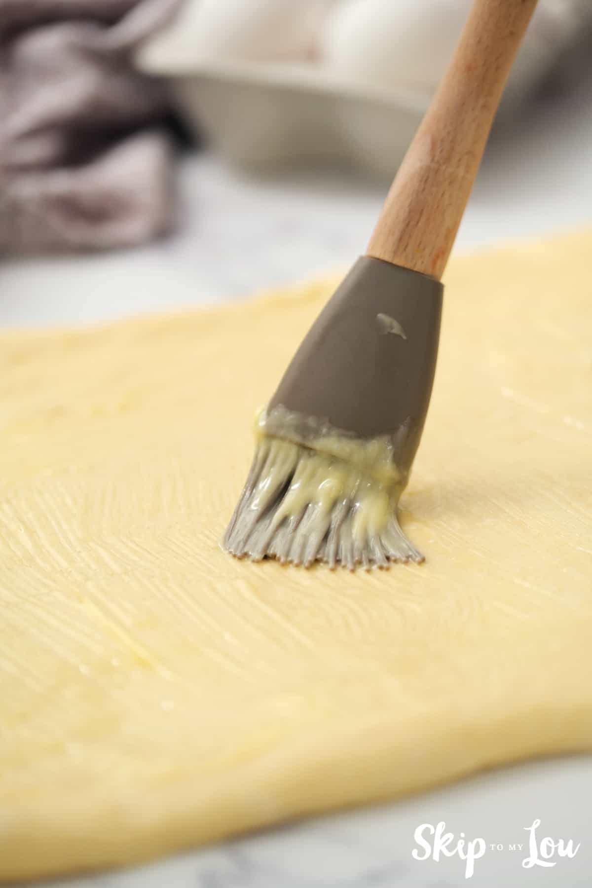 Melt about 3 Tablespoons of butter and spread over top of dough.