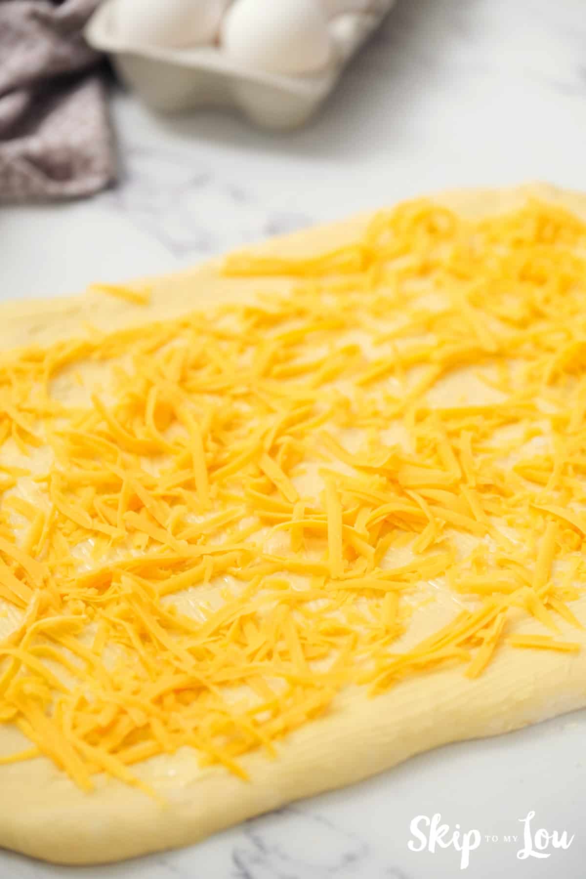 Cover dough with 1/4 teaspoon Kosher salt,  about a cup of grated cheddar cheese, 1/4 cup Parmesan cheese and a light sprinkling of oregano (or your favorite herbs).